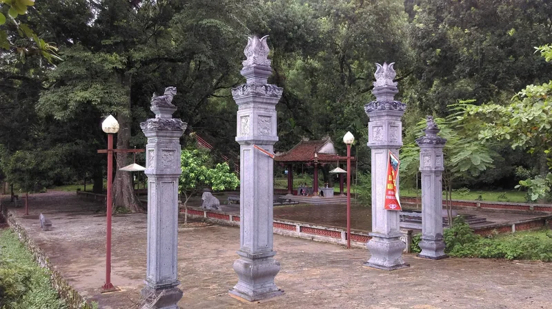 Các cột trụ đá dẫn vào ngôi đền nhỏ tại Đền Bà Triệu giữa rừng cây xanh mát.